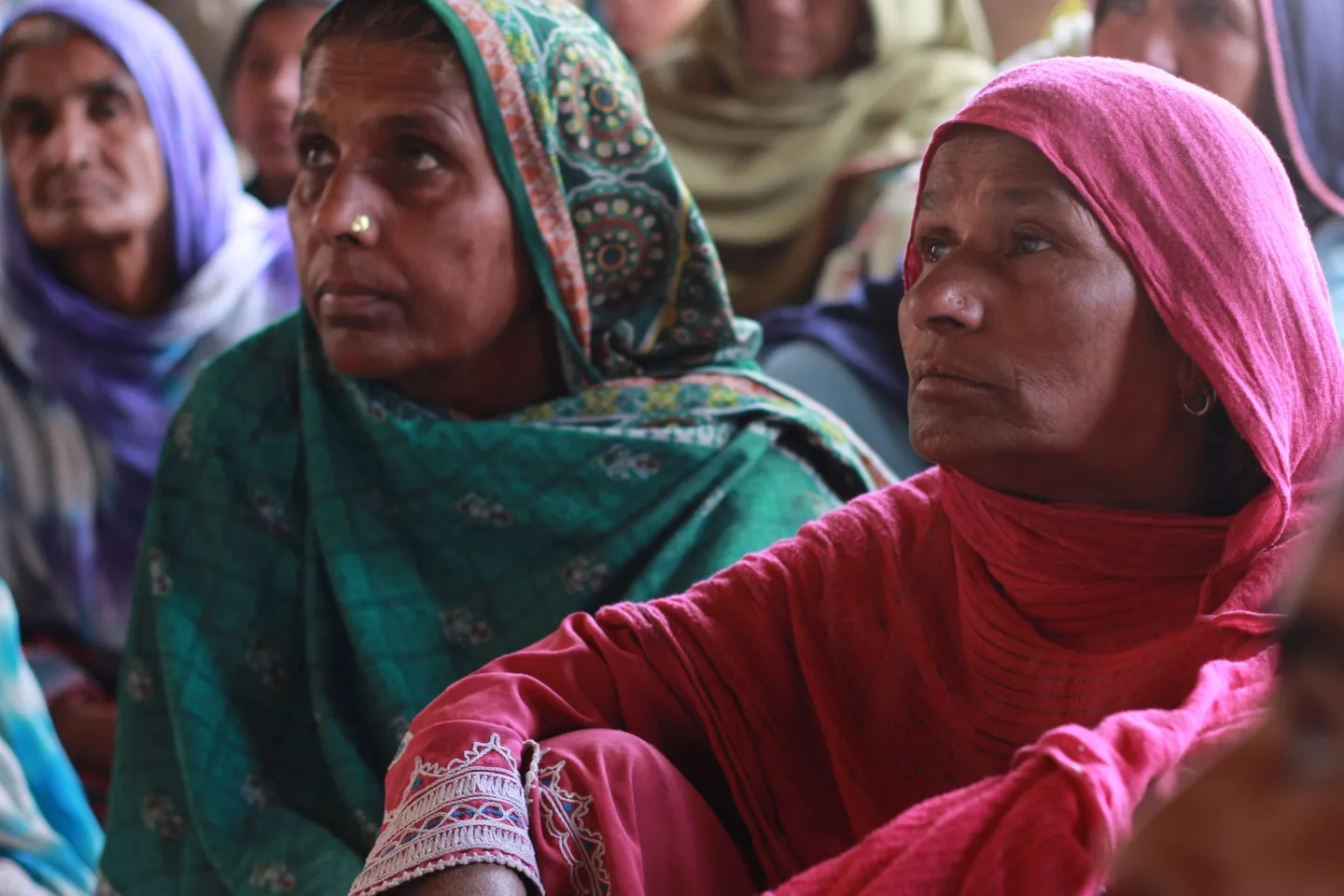 Women listening attentively during a community training session in India