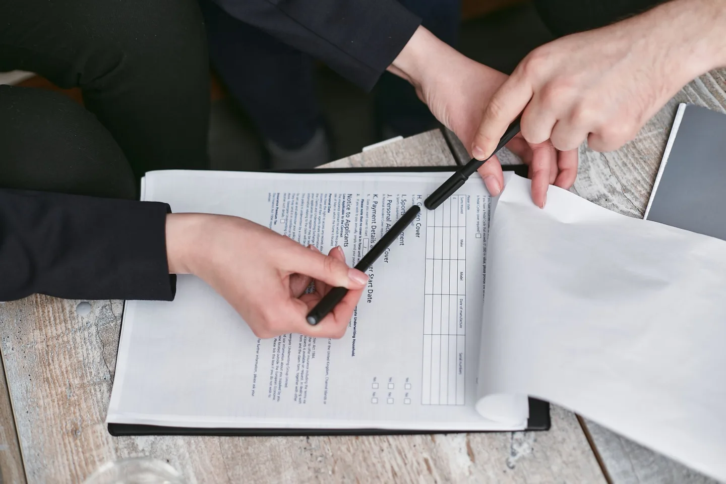 Hands reviewing and signing documents during a records check