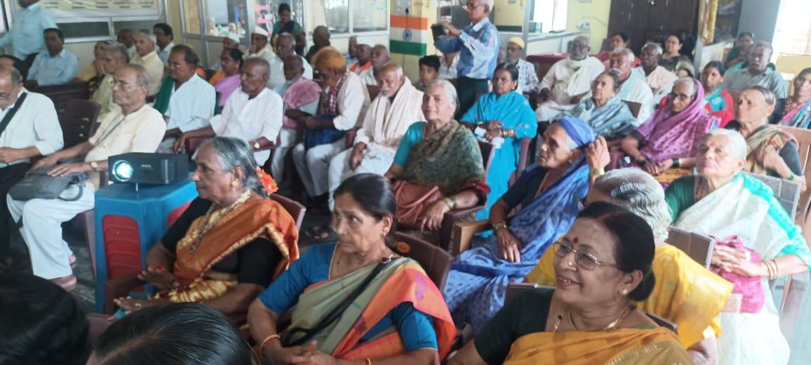 Senior citizens seated in the hall watching the bone health presentation